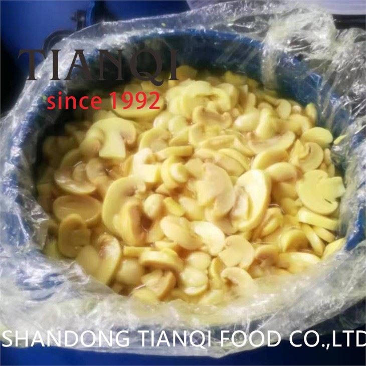 Preserved white champignon mushroom in big drums